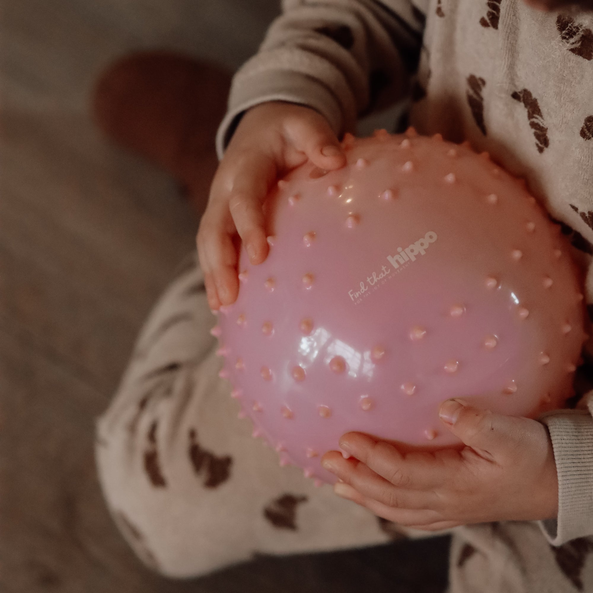 Close-up of child holding a dusty pink sensory ball  – Find That Hippo