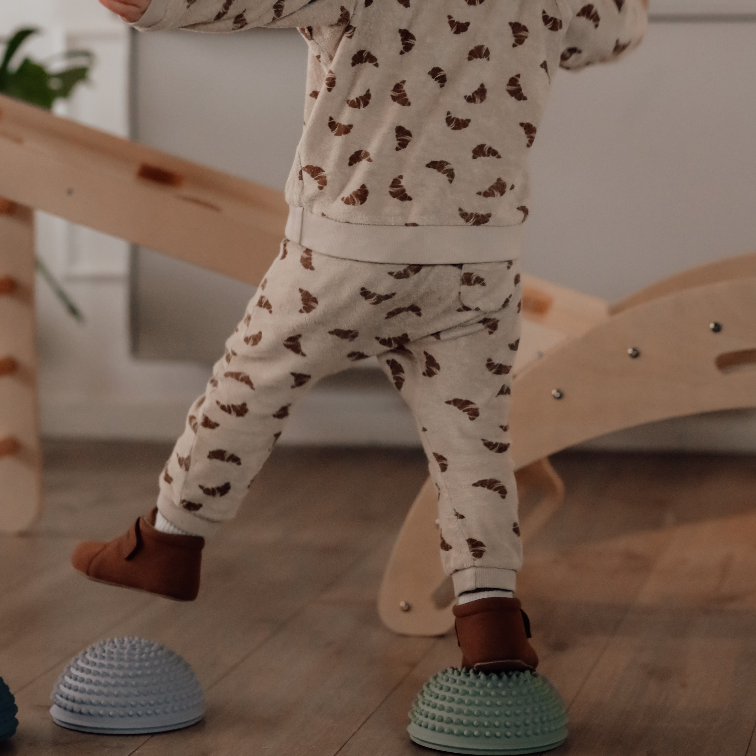 Child wearing dotted leggings stepping on blue sensory stone indoors – Find That Hippo