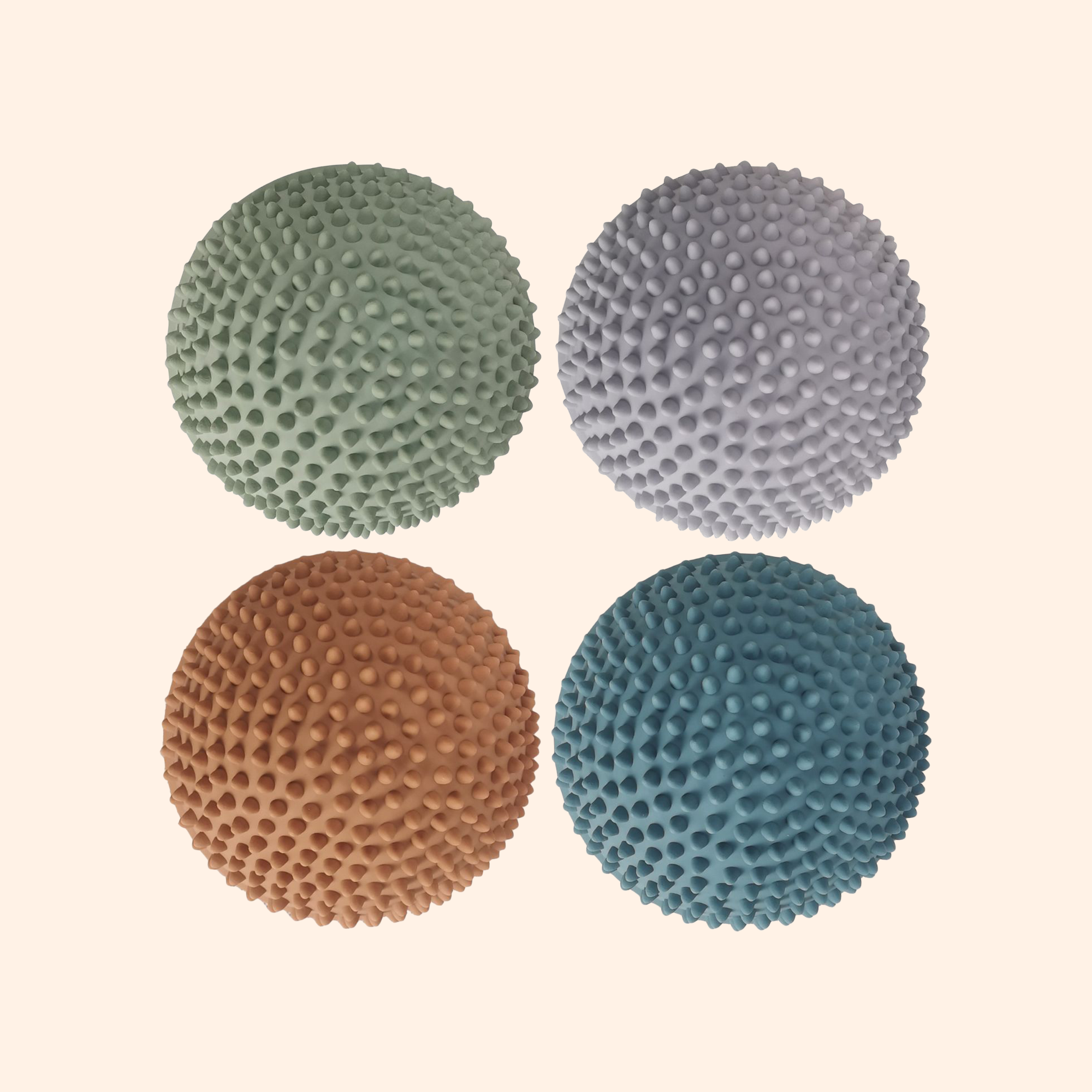 Top-down view of four Solnedgang sensory stones in petrol, dusty green, muted orange, and lavender gray – Find That Hippo