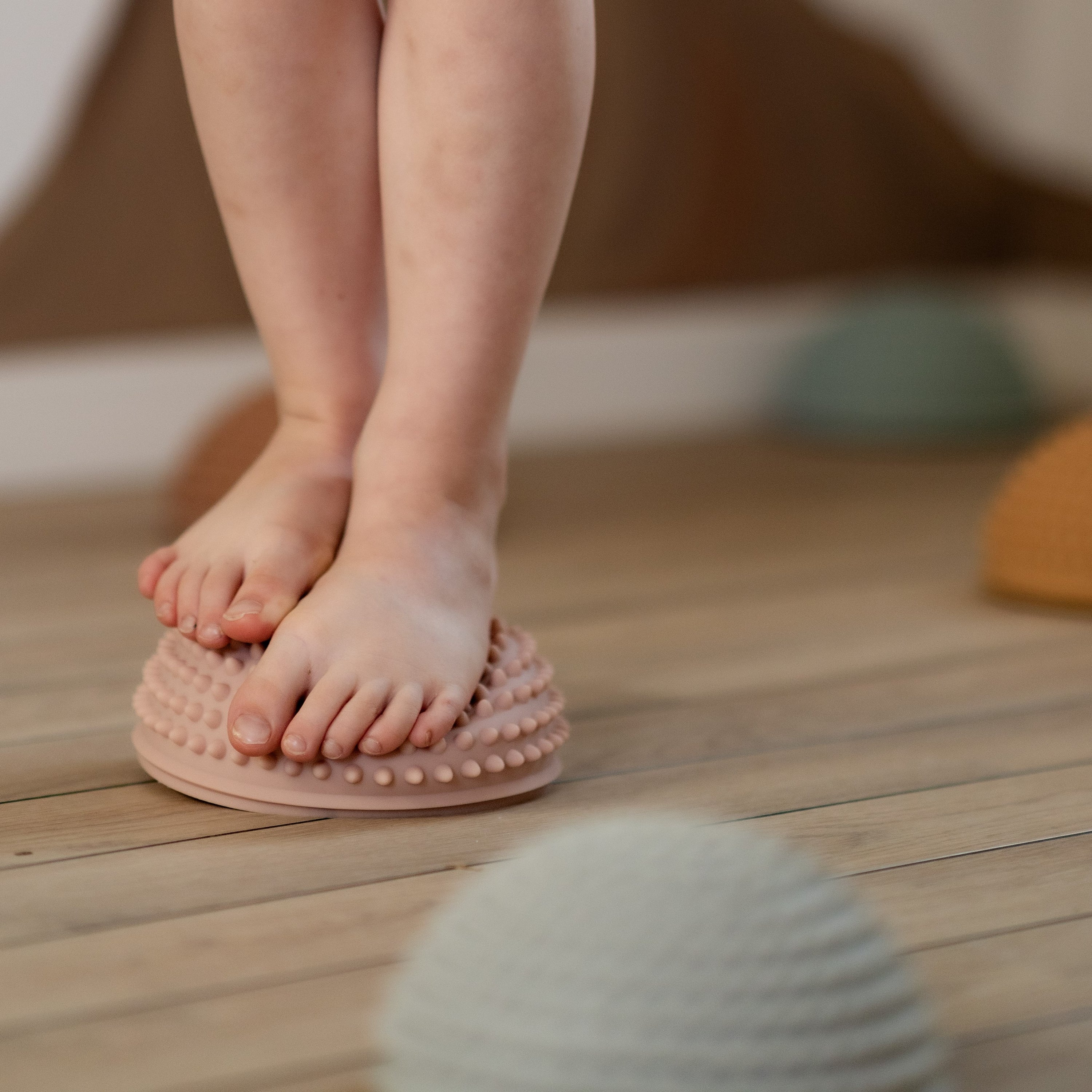 Child placing foot on ochre sensory stone with small tactile knobs – Solopgang set from Find That Hippo